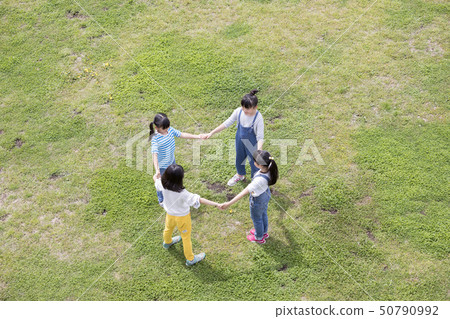 握在草的手和形成圈子的孩子 50790992