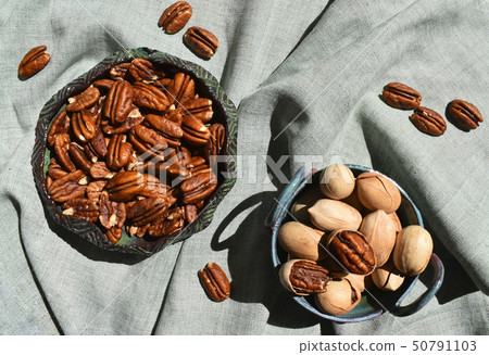 Pecan in ceramic bowl. Unpeeled nuts in shell deep green rustic porcelain. Organic raw healthy diet Pecan in ceramic bowl. Unpeeled nuts in shell deep green rustic porcelain. Organic raw healthy diet 50791103