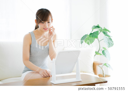 Woman checking skin with mirror Woman checking skin with mirror 50791555