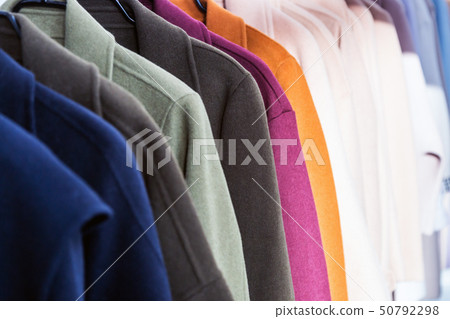 coats of different colors hang on a hanger   50792298
