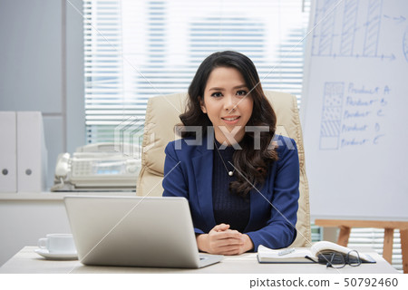 Businesswoman sitting at her workplace at office Businesswoman sitting at her workplace at office 50792460