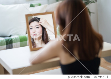 Woman looking in the mirror Woman looking in the mirror 50794391