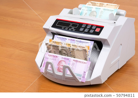 Indian rupee in a counting machine  50794811