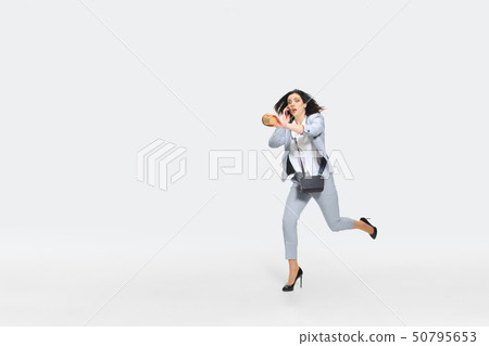 Young woman comes late for work Young woman comes late for work 50795653