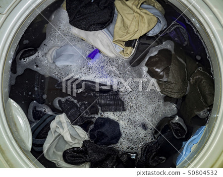 Top loading washing machine washes laundry. 50804532
