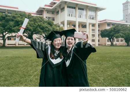 friend hugging together raising hand with diploma 50810062