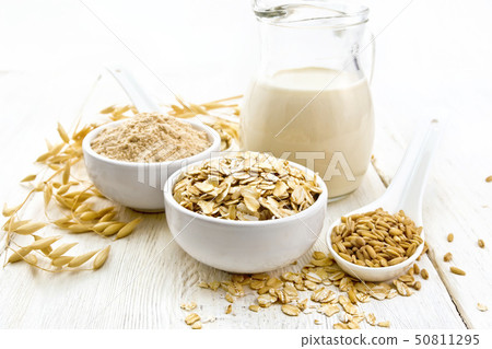 Oat flakes with flour and milk on wooden board Oat flakes with flour and milk on wooden board 50811295