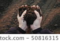 Farmer holding soil in hands close-up 50816315