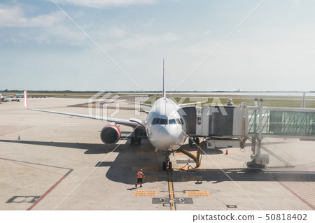 Modern commercial passenger airplane parked to airport terminal building 50818402
