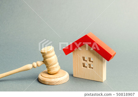 Miniature wooden house and judge's hammer.  50818907