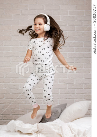 little child girl listening to the music with the headphones little child girl listening to the music with the headphones 50820717