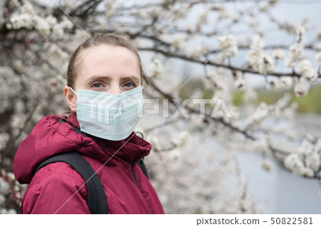 Sad young woman in protective medical face mask. Sad young woman in protective medical face mask. 50822581