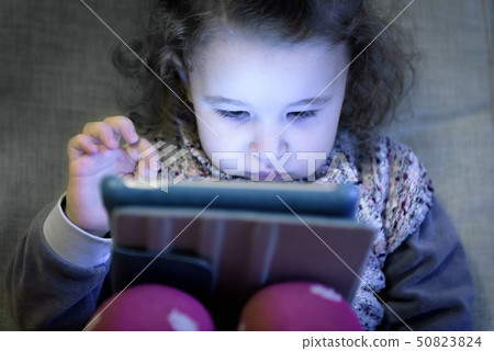 Little girl uses a digital tablet Little girl uses a digital tablet 50823824