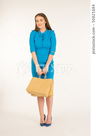 Pretty woman in blue dress posing with bags Pretty woman in blue dress posing with bags 50825884