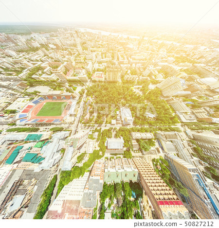 Aerial city view with crossroads and roads, houses, buildings, parks and parking lots. Sunny summer 50827212
