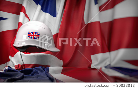 White hard hat laying over UK  flag. Construction 50828818