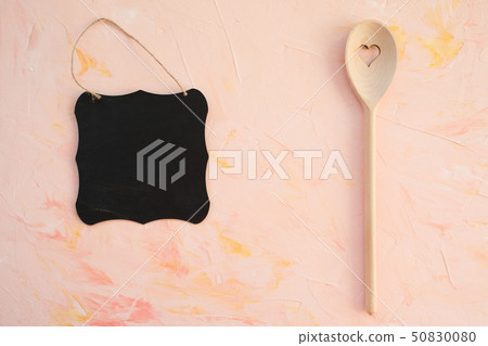 Empty blackboard and stirring spoon on a pink Empty blackboard and stirring spoon on a pink 50830080