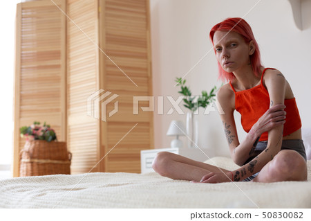 Anorexic woman with tattoos on arms feeling miserable Anorexic woman with tattoos on arms feeling miserable 50830082