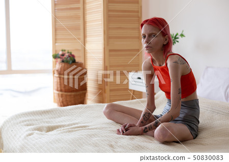 Woman with bulimia sitting on bed feeling bad and lonely Woman with bulimia sitting on bed feeling bad and lonely 50830083
