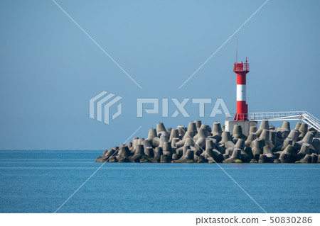 Lighthouse on a breakwater in the blue sea 50830286