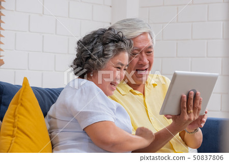 Asian senior couple use tablet video call and talk 50837806