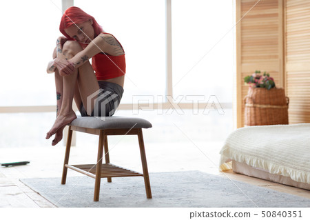 Red-haired tattooed woman with bulimia feeling sad and lonely Red-haired tattooed woman with bulimia feeling sad and lonely 50840351