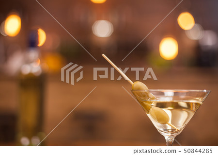 Close up of a glass with martini and blurred bart counter in the back 50844285