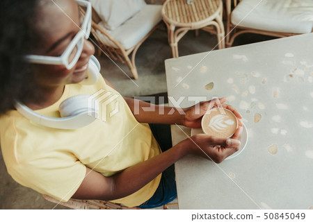 Cropped photo of African woman having rest and drinking coffee in cafeteria Cropped photo of African woman having rest and drinking coffee in cafeteria 50845049