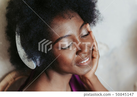 Close up portrait of happy woman listening to music indoors 50845147