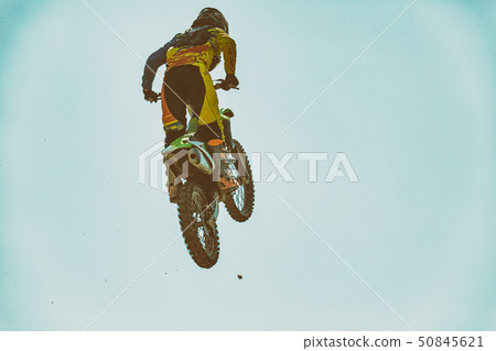 A picture of a biker making a stunt and jumps in the air A picture of a biker making a stunt and jumps in the air 50845621