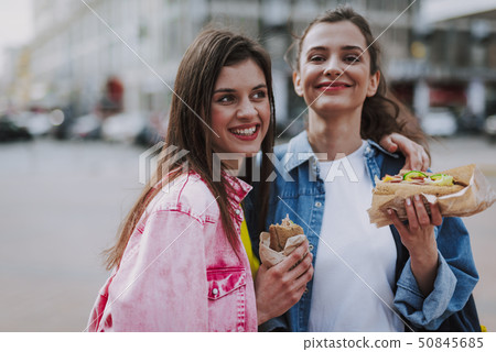 Happy female friends making photo with hot dogs 50845685