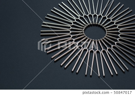 Tuning fork round pattern on a black background Tuning fork round pattern on a black background 50847017