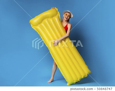 Happy millennial girl holding inflatable mattress, ready to chill out in pool Happy millennial girl holding inflatable mattress, ready to chill out in pool 50848747