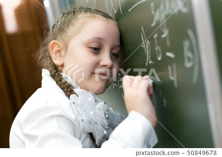 The girl buried her head in the school board. 50849678