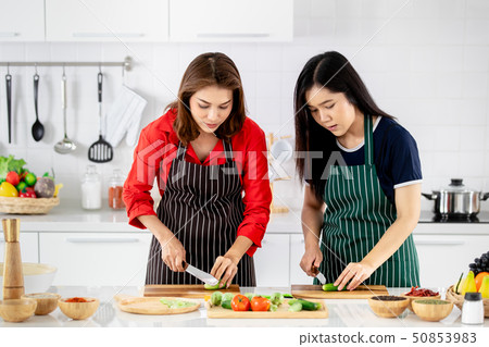 Beautiful Asian woman teaching her daughter for cooking. 50853983