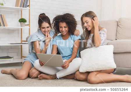 Happy roommates using laptop, surfing internet at home 50855264