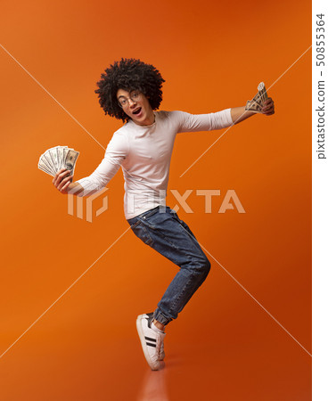 Happy african american guy dancing on tiptoes with money fans Happy african american guy dancing on tiptoes with money fans 50855364