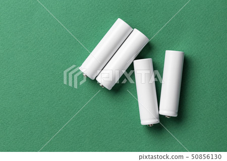 white batteries on a green background white batteries on a green background 50856130