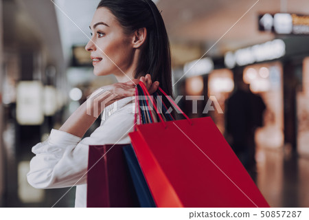 Jolly young woman with paper bags at airport 50857287