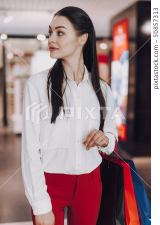Carefree young woman is carrying paper bags 50857313