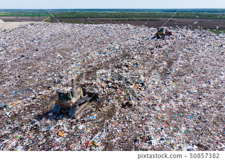 two bulldozer working on mountain of garbage in landfill two bulldozer working on mountain of garbage in landfill 50857382