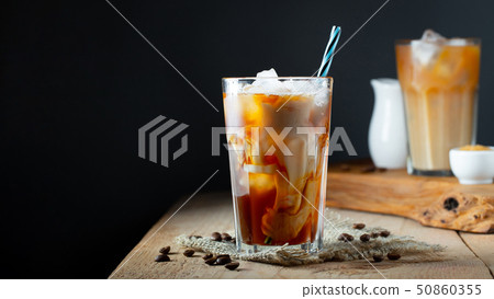 Ice coffee in a tall glass with cream. 50860355