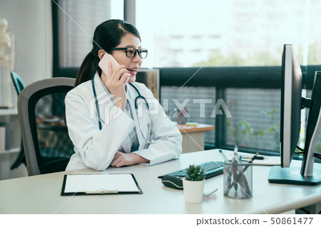 asian female doctor using mobile phone talking asian female doctor using mobile phone talking 50861477
