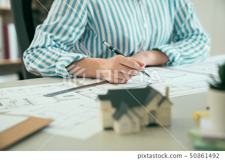 woman hand writing drawing plan on blue print woman hand writing drawing plan on blue print 50861492