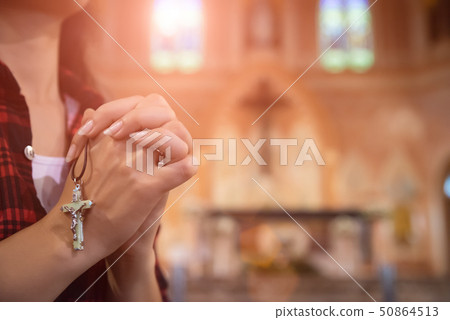 Woman hand praying to God at church. Woman hand praying to God at church. 50864513