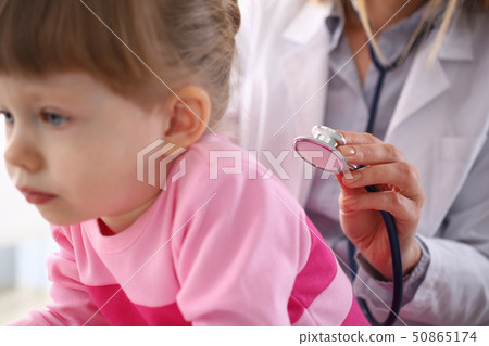 Female doctor arm hold stethoscope measuring patient heartbeat Female doctor arm hold stethoscope measuring patient heartbeat 50865174