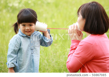 Parent and child speaking on a thread phone Parent and child speaking on a thread phone 50867085