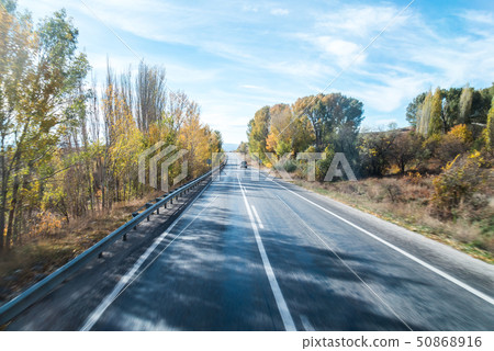 有秋葉的一條平直的高速公路在兩邊 有秋葉的一條平直的高速公路在兩邊 50868916