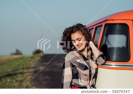 A young girl on a roadtrip through countryside, standing by a minivan. A young girl on a roadtrip through countryside, standing by a minivan. 50878347