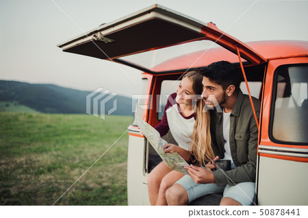 A young couple on a roadtrip through countryside, looking at a map. A young couple on a roadtrip through countryside, looking at a map. 50878441